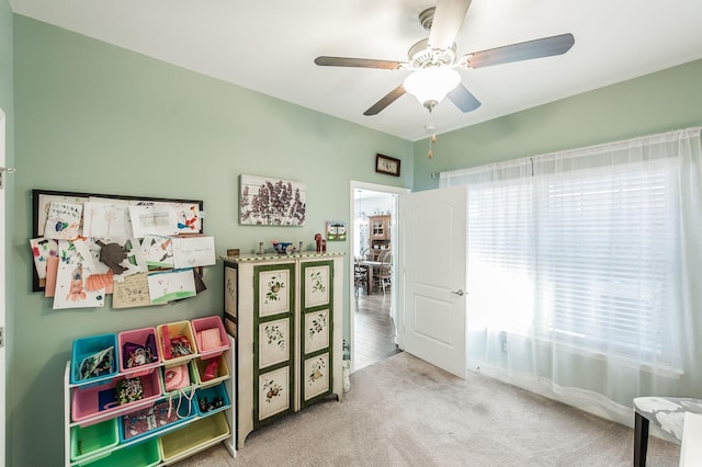 playroom with light carpet and ceiling fan