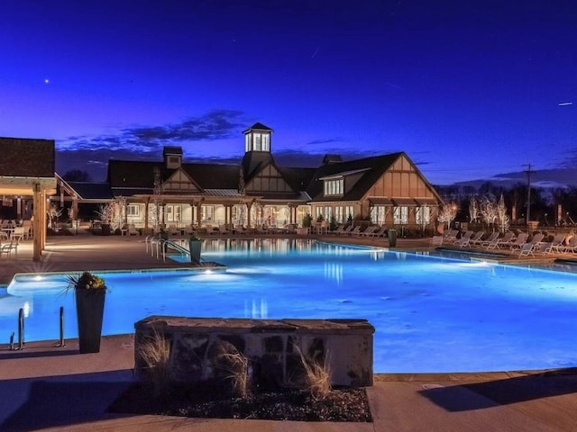 pool at dusk featuring a patio