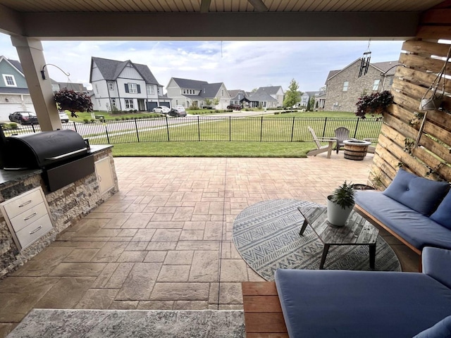 view of patio with area for grilling, a grill, and a fire pit