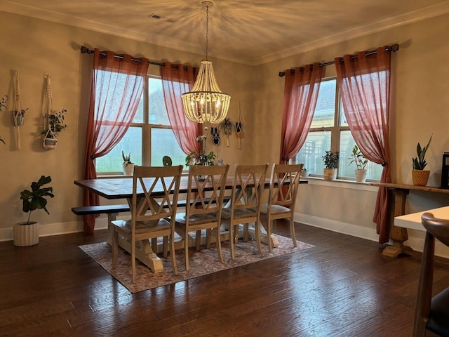 dining area with crown molding, dark wood-type flooring, and an inviting chandelier