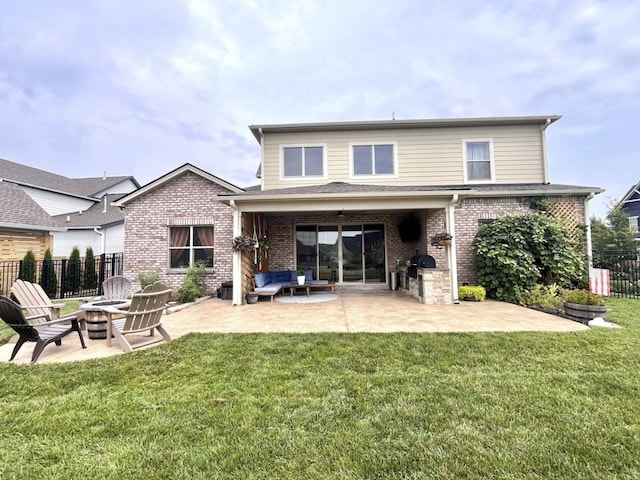 back of house featuring exterior kitchen, a patio, a yard, and an outdoor fire pit