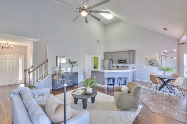 living room with plenty of natural light, vaulted ceiling, a textured ceiling, and light hardwood / wood-style flooring