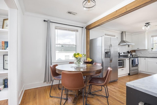 dining room featuring ornamental molding and light hardwood / wood-style flooring