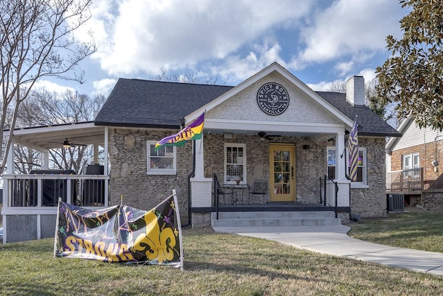 view of front of house featuring ceiling fan, cooling unit, covered porch, and a front lawn