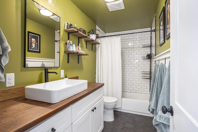 full bathroom with tile patterned floors, toilet, shower / bath combo with shower curtain, and vanity