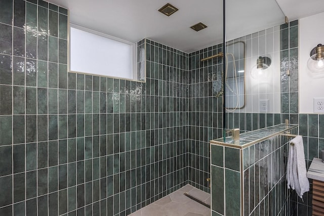 bathroom with a tile shower and tile walls