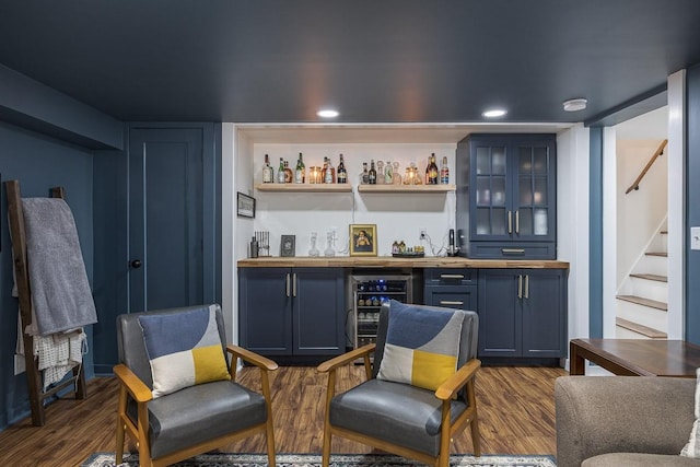 bar featuring wine cooler, blue cabinets, and dark hardwood / wood-style floors