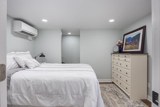 bedroom with hardwood / wood-style flooring and a wall unit AC