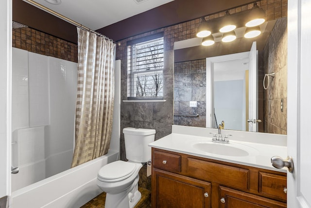 full bathroom with shower / tub combo with curtain, vanity, toilet, and tile walls