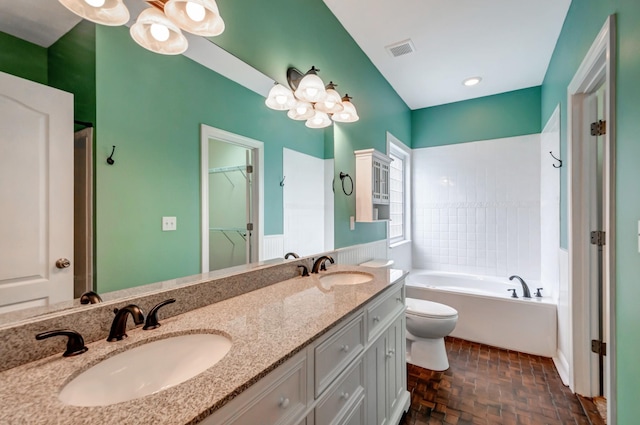 full bath with double vanity, a garden tub, visible vents, a sink, and toilet