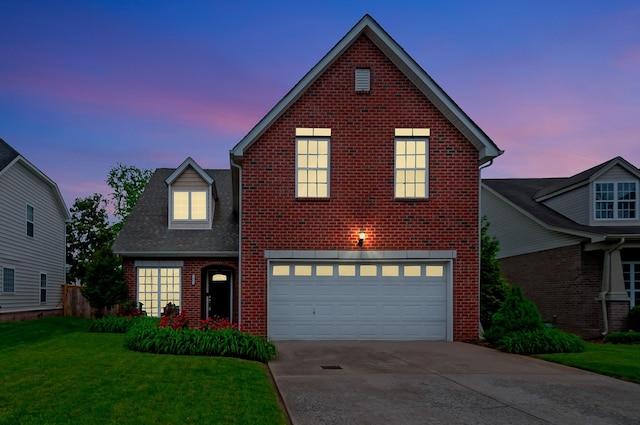 traditional-style house featuring brick siding, an attached garage, driveway, and a front yard