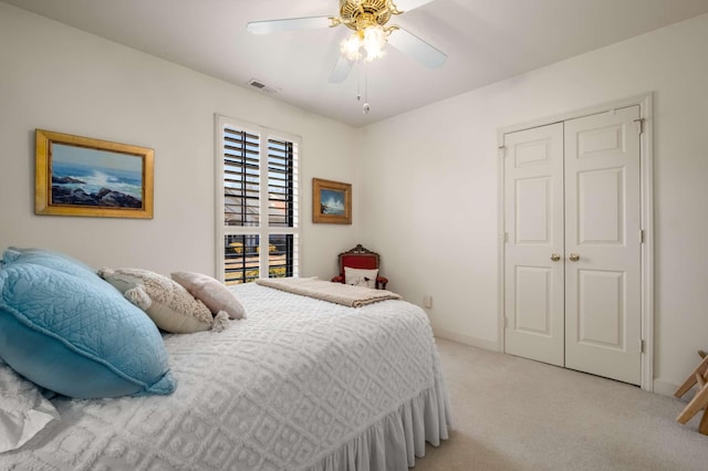 bedroom featuring light colored carpet, a closet, and ceiling fan