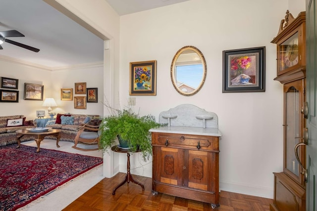 living room with ceiling fan, dark parquet flooring, and ornamental molding