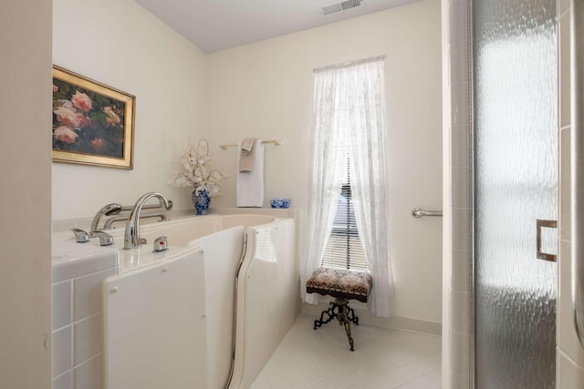 bathroom with a healthy amount of sunlight, a bath, and tile patterned floors