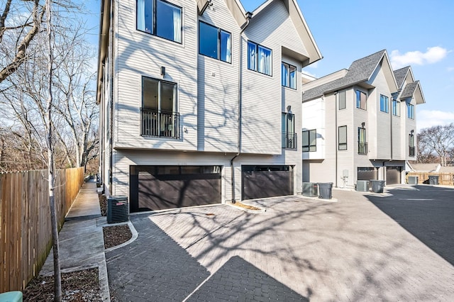 view of property exterior with a garage and central air condition unit