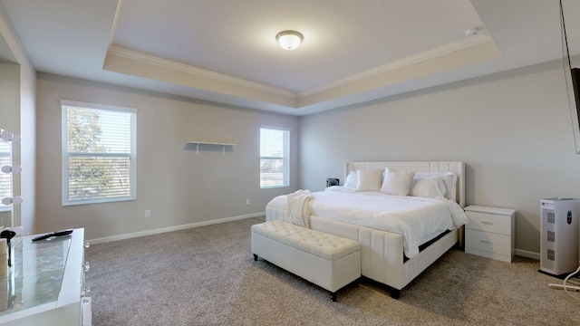 bedroom featuring crown molding, a tray ceiling, and carpet flooring