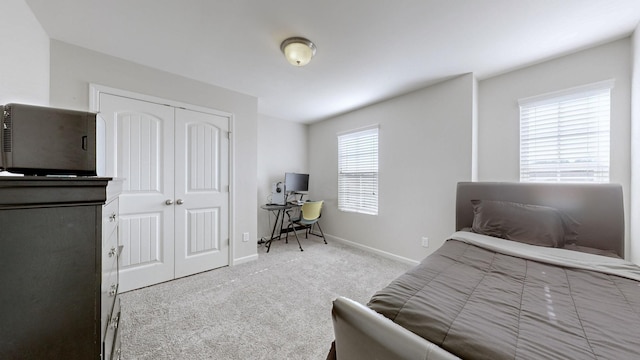 bedroom featuring light colored carpet and a closet