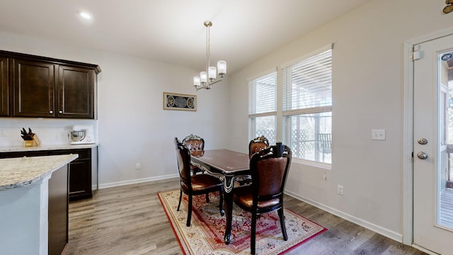 dining area featuring light hardwood / wood-style floors and a chandelier