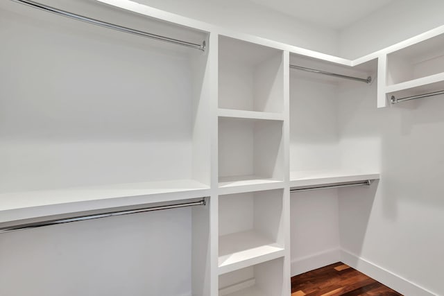 walk in closet with dark wood-type flooring