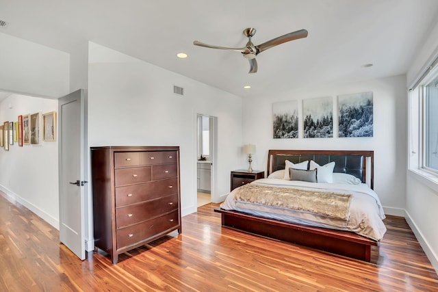 bedroom with ceiling fan, ensuite bath, and hardwood / wood-style floors