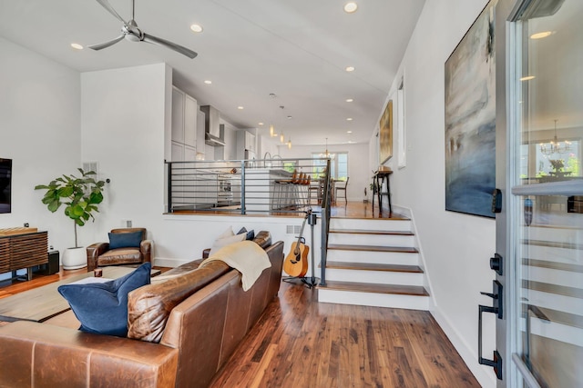 living room featuring ceiling fan with notable chandelier and hardwood / wood-style floors