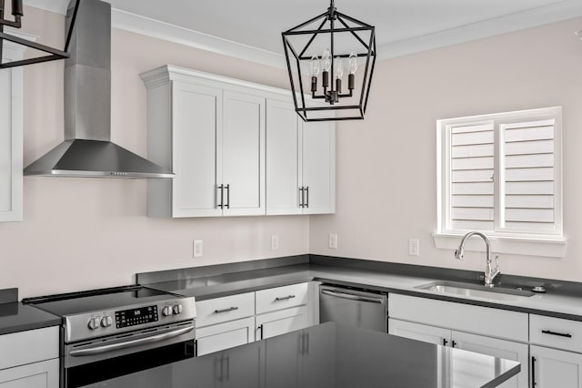 kitchen with sink, hanging light fixtures, appliances with stainless steel finishes, wall chimney range hood, and white cabinets