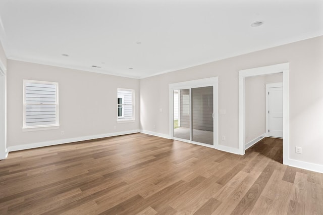 spare room featuring crown molding and light wood-type flooring