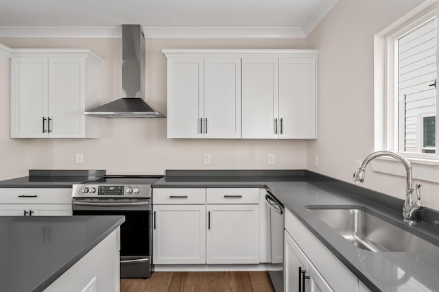 kitchen featuring white cabinets, appliances with stainless steel finishes, and wall chimney range hood