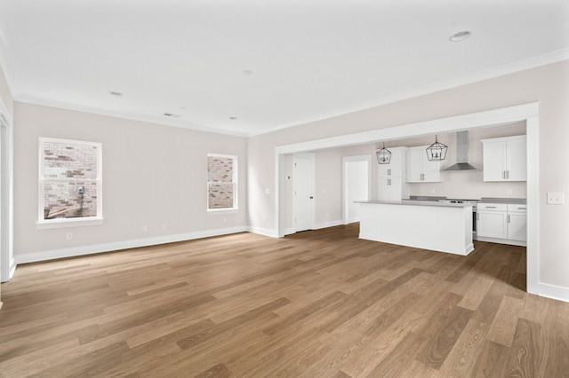 unfurnished living room featuring ornamental molding and light hardwood / wood-style flooring