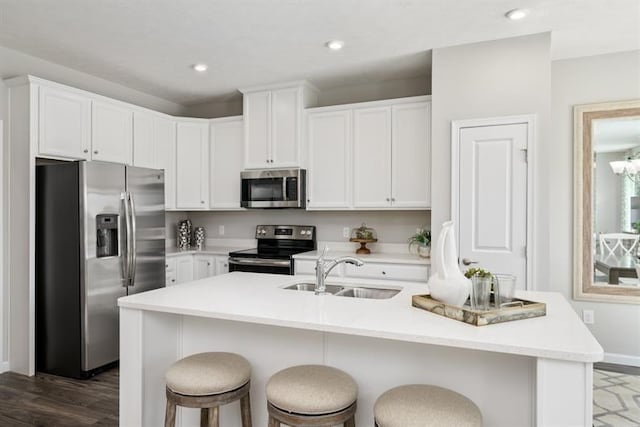 kitchen featuring white cabinetry, stainless steel appliances, a kitchen island with sink, and sink