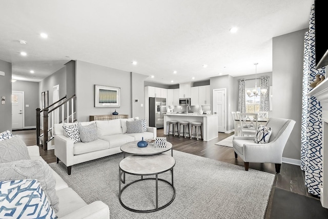 living room with an inviting chandelier, sink, and dark hardwood / wood-style floors