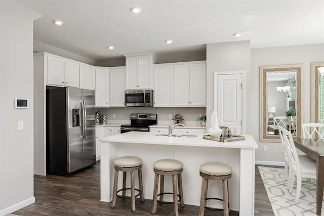 kitchen featuring sink, white cabinetry, stainless steel appliances, a center island with sink, and dark hardwood / wood-style flooring