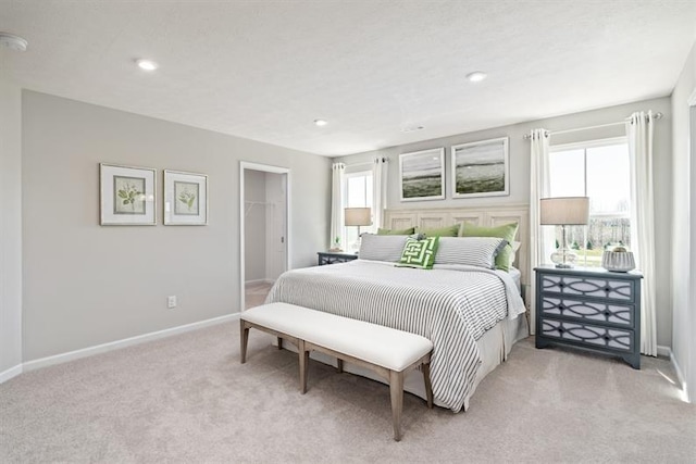 bedroom featuring light carpet and multiple windows