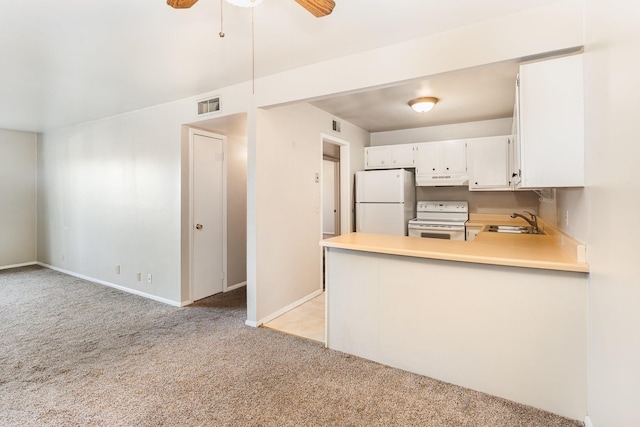 kitchen featuring sink, white appliances, white cabinetry, light carpet, and kitchen peninsula