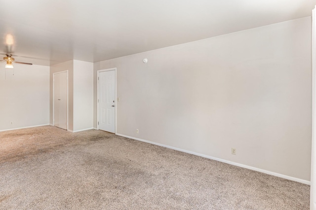 carpeted spare room featuring ceiling fan