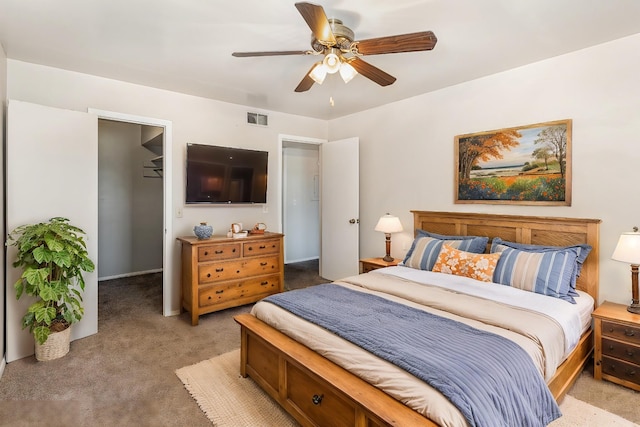 bedroom featuring light carpet, a spacious closet, a closet, and ceiling fan