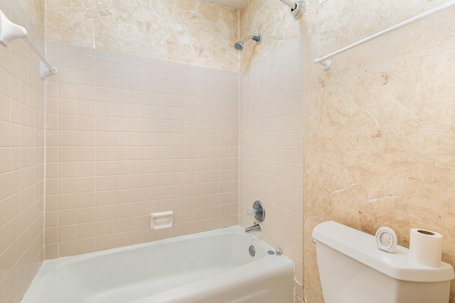 bathroom featuring tiled shower / bath combo and toilet