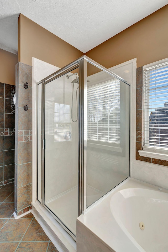 bathroom featuring tile patterned flooring, plus walk in shower, and a textured ceiling