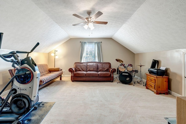 exercise room with ceiling fan, light colored carpet, lofted ceiling, and a textured ceiling