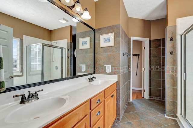 bathroom featuring vanity, tile patterned flooring, a textured ceiling, and walk in shower