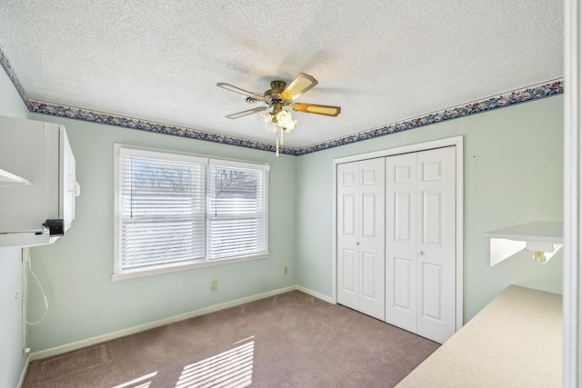 unfurnished bedroom featuring ceiling fan, carpet flooring, a textured ceiling, and a closet