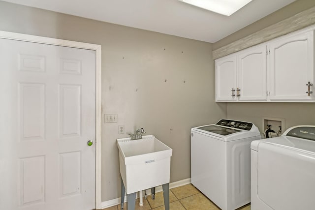 washroom featuring light tile patterned flooring, cabinets, sink, and washer and dryer