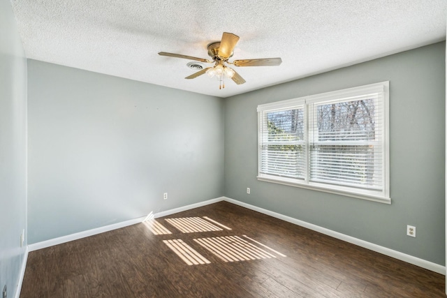 empty room featuring a textured ceiling, dark hardwood / wood-style floors, and ceiling fan