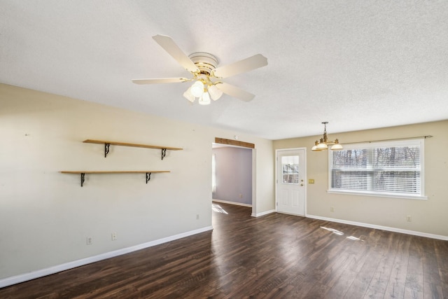 unfurnished living room with ceiling fan with notable chandelier, dark hardwood / wood-style floors, and a textured ceiling