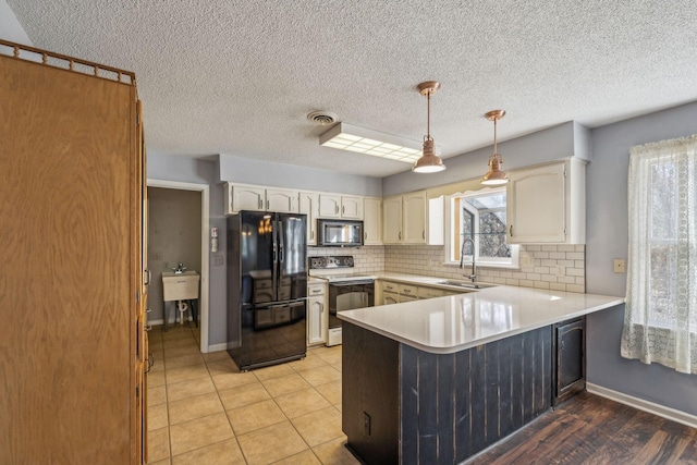 kitchen with decorative light fixtures, black appliances, sink, white cabinets, and kitchen peninsula