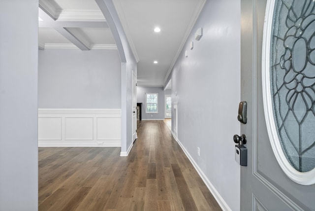 hall with ornamental molding, dark hardwood / wood-style floors, and beam ceiling