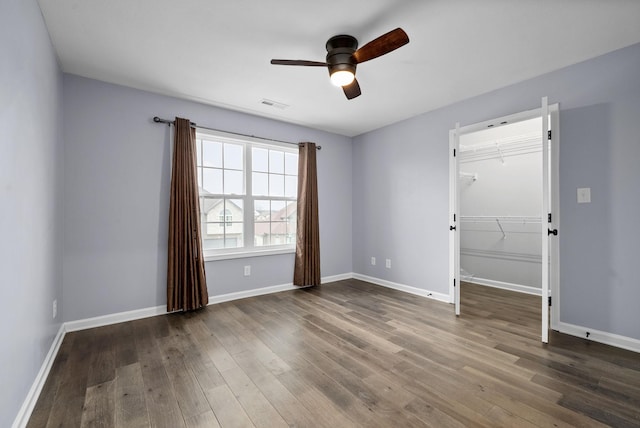 empty room with ceiling fan and dark hardwood / wood-style flooring