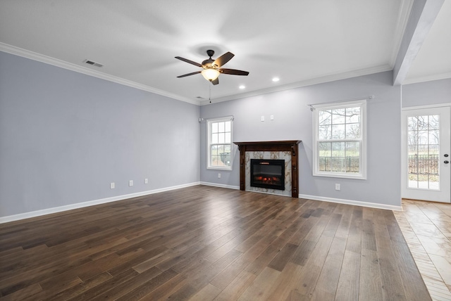 unfurnished living room with dark hardwood / wood-style flooring, crown molding, a premium fireplace, and ceiling fan