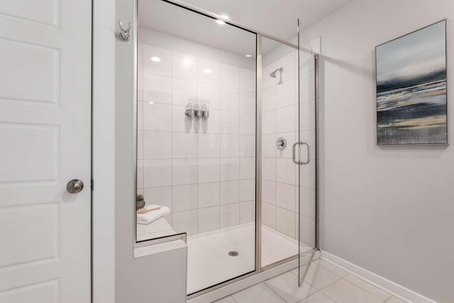 bathroom with an enclosed shower and tile patterned flooring