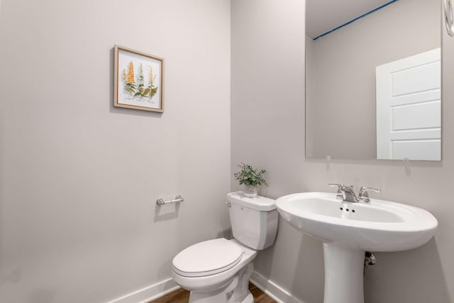 bathroom with hardwood / wood-style flooring and toilet